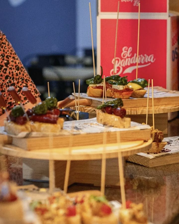 Pintxos a la barra en safates de fusta, amb el vermut El Bandarra al fons